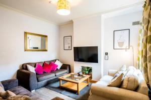 a living room with two couches and a tv at The Tigers Townhouse in Leicester