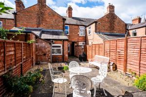 a patio with a table and chairs and brick buildings at The Tigers Townhouse in Leicester