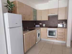 a kitchen with a white refrigerator and a dishwasher at Pyla Palms Resort B1 - 1 in Larnaca