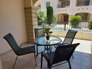 eine Terrasse mit einem Tisch und Stühlen auf dem Balkon in der Unterkunft Pyla Palms Resort B1 - 1 in Larnaka