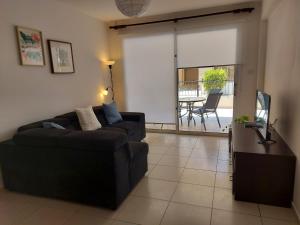ein Wohnzimmer mit einem Sofa und einem Tisch in der Unterkunft Pyla Palms Resort B1 - 1 in Larnaka
