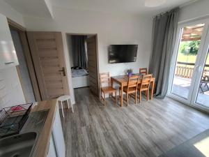 a kitchen and dining room with a table and chairs at NASZE 4 KĄTY in Junoszyno +31 photos
