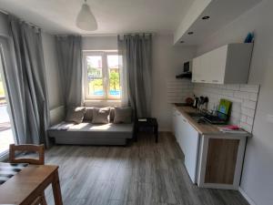 a small living room with a couch and a kitchen at NASZE 4 KĄTY in Junoszyno