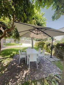 a white table and chairs under an umbrella at Villa Cycas in Ischia