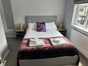 ein Schlafzimmer mit einem Bett mit zwei Handtüchern darauf in der Unterkunft Orchard View Lodge in Woodhall Spa
