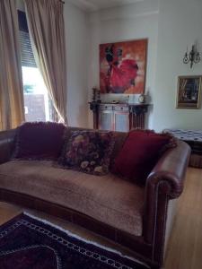 a living room with a brown couch in a room at Villa by the river near meteora in Tríkala