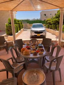 une table avec de la nourriture et une voiture garée dans une allée dans l'établissement German-Palestinian Appartement, à Al Khalīl