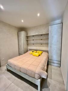 a bedroom with a large bed with yellow pillows at CASA MILA in Marina di Cerveteri