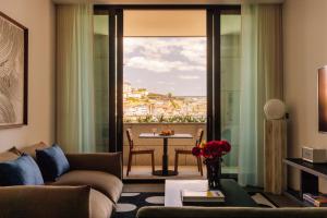 uma sala de estar com um sofá e uma mesa em The Rebello Hotel & Spa - Small Luxury Hotels Of The World em Vila Nova de Gaia