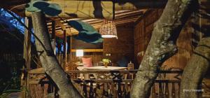 een eetkamer met een tafel en een boom bij Villas Light House - Eco-Traditional Joglo in Gili Trawangan