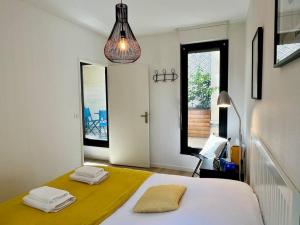 a bedroom with a bed with a yellow blanket at Le Nid d'Erlon - Reims in Reims