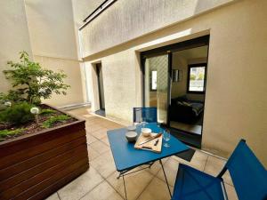 a blue table and two chairs in a patio at Le Nid d'Erlon - Reims in Reims