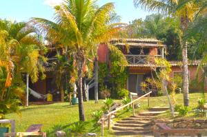 uma casa com palmeiras em frente em Salto Corumbá Hotel Camping Clube em Corumbá de Goiás