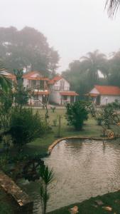 普拉多斯的住宿－Chalés Jatobá，一群房子和院子中的池塘
