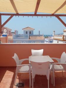 a white table and chairs in a room with a view at Casa Calypso San Juan de los Terreros in San Juan de los Terreros