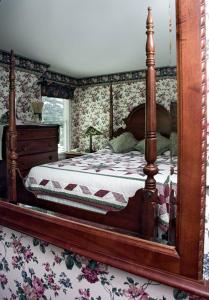 a bedroom with a bed and a dresser and a mirror at Woodstock Inn, Station and Brewery in North Woodstock
