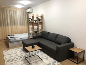 uma sala de estar com um sofá preto e uma cama em ДОМ1 em Varna City