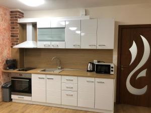 uma cozinha com armários brancos e um micro-ondas em ДОМ1 em Varna City