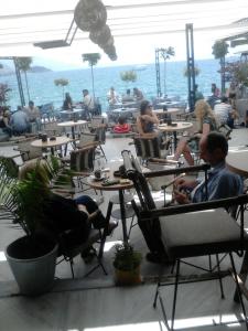 a group of people sitting at tables in a restaurant at Orhidea House in Ohrid