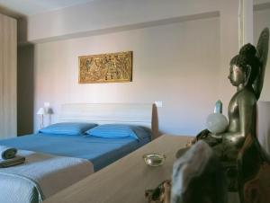 a bedroom with two beds and a statue on a table at Appartamento a 50 mt dal mare in Rosignano Solvay