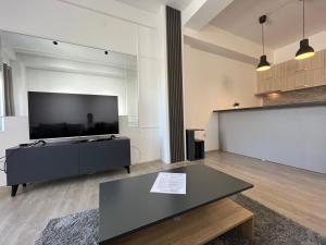 a living room with a flat screen tv and a table at Apartments IVI Gevgelija in Gevgelija