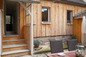 een houten huis met een veranda en een patio bij Ferienhaus Dani in Bad Frankenhausen