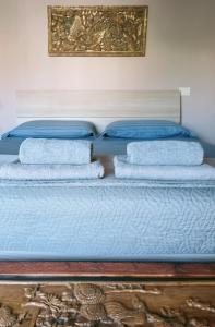 a bed with blue sheets and towels on it at Appartamento a 50 mt dal mare in Rosignano Solvay