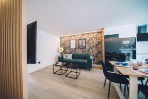 ein Wohnzimmer mit einem grünen Sofa und einem Tisch in der Unterkunft Casa playa Las Sinas in Vilanova de Arousa