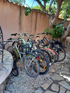 una fila de bicicletas estacionadas junto a una pared en Le CLOS D'AMANDINE, en Sallèles-dʼAude