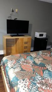 1 dormitorio con 1 cama y vestidor con TV en Bel Air Motor Lodge, en Maple Shade