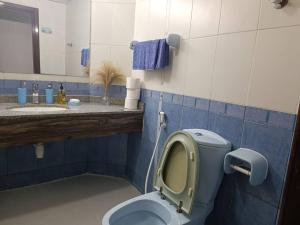 Baño azul con aseo y lavamanos en شقة كبيرة وفخمة large and luxury two bedroom en Ajman 
