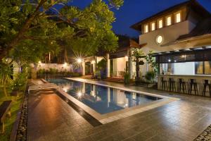a swimming pool in front of a house at night at Elshape Holiday HOME in Melaka