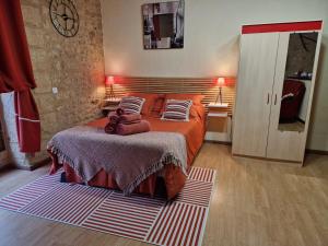 - une chambre avec un lit doté de draps et d'oreillers rouges dans l'établissement Les Flamboyants, à Sarlat-la-Canéda