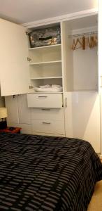 1 dormitorio con armarios blancos y 1 cama en Departamento Vista Cordillera, en Santiago