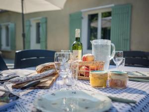 einen Tisch mit einer Flasche Wein und einem Korb mit Speisen in der Unterkunft Chez Hélene in Sarlat-la-Canéda