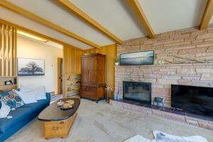 a living room with a blue couch and a fireplace at Point Roberts Cottage with Ocean Views and Hot Tub! in Point Roberts