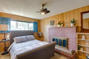 Point Roberts Cottage with Ocean Views and Hot Tub! في Point Roberts: غرفة نوم مع سرير ومدفأة من الطوب