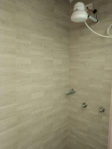 a bathroom with a shower with a light on the wall at Centro Histórico, candelaria -est Las aguas in Bogotá