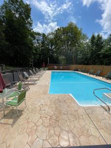 a swimming pool with chairs and a table at English Brook Cottages in Lake George