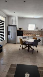La cuisine est équipée d'une table et d'un réfrigérateur en acier inoxydable. dans l'établissement Maison Provence, proche Avignon, à Sorgues