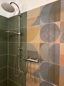 a bathroom with a shower with colorful tiles on the wall at Chez Madame in Ferrara