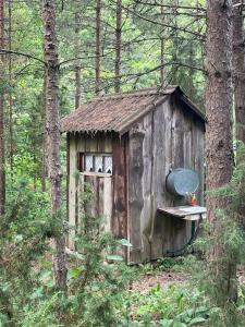 an old out house with a bench in the woods at Nugise onn in Pallasmaa