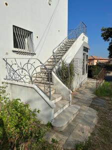 a set of stairs leading up to a white house at *.* Haut de villa U Nespulu di Anghjulina *.* in Borgo
