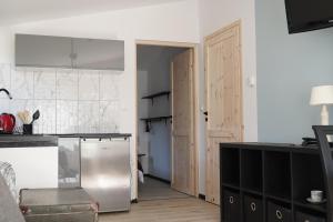 kuchnia z lodówką ze stali nierdzewnej i drzwiami w obiekcie Siwy Dom w Turawie
