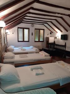 a room with four beds and a ceiling with beams at Apartman Kamen 1 in Negotin