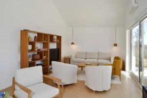sala de estar con sillas blancas y sofá en Sobreiras Alentejo Country Hotel - by Unlock Hotels, en Santa Margarida da Serra