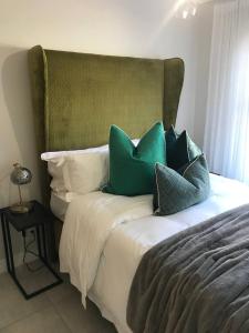 a bed with green and white pillows on it at Haven Sanctuary in Avalon
