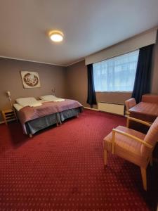 a bedroom with a bed and a large window at Strand Fjordhotel in Ulvik