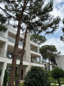 an apartment building with trees in front of it at EME APARTMENTS - Kompleksi San Pietro, Gjiri i Lalzit in Durrës