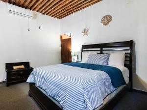 a bedroom with a bed with a blue and white comforter at OYO Posada Del Pescador in Cabo San Lucas